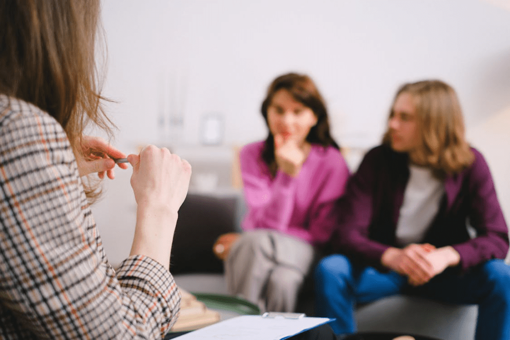 Couple and therapist discussing relationship on a couch in an office