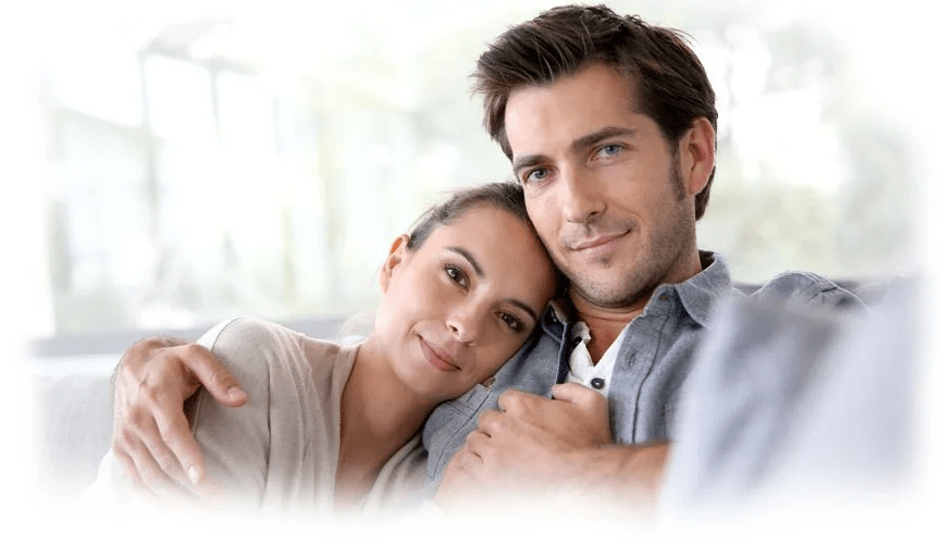 A woman smiling with her head on her partner's shoulder.